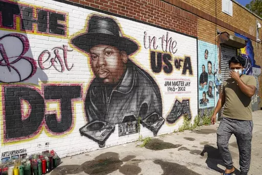 A pedestrian passes a mural of rap pioneer Jam Master Jay of Run-DMC, by artist Art1Airbrush, Aug. 18, 2020, in the Queens borough of New York. A third man has been charged in the 2002 shooting death of hip-hop trailblazer Jam Master Jay, prosecutors said Tuesday, May 30, 2023, adding another suspect in the Run-DMC member's killing which for years after it initially happened had languished as a cold case. (AP Photo/John Minchillo, File)