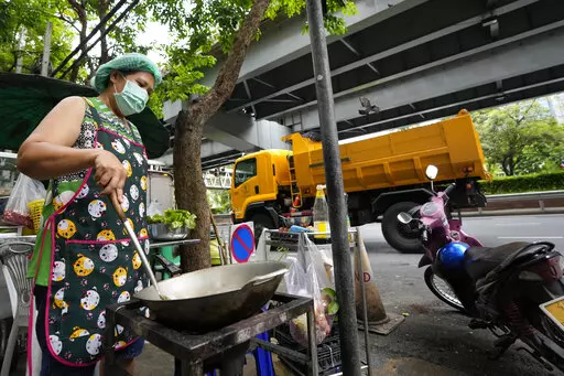 Street food vendor Warunee Deejai cooks lunch for customers in Bangkok, Thailand, Thursday, Aug. 11, 2022. In the six months since Russia invaded Ukraine, the fallout from the war has had huge effects on the global economy. Though intertwined with other forces, the war has made problems like inflation much worse for people around the world. In Bangkok, rising costs for pork, vegetables and oil have forced Warunee Deejai, a street-food vendor, to raise prices, cut staff and work longer hours. (AP