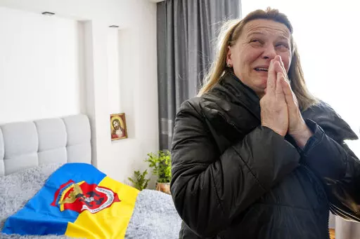 Maria Pavlovych weeps as she remembers her 25-year-old soldier son, Roman Pavlovych, who was killed near the besieged city of Mariupol, in his bedroom, in Hordynia village, western Ukraine, Friday, March 25, 2022. The Pavlovych family knows a second front line in Russia's war runs through the farmland here in western Ukraine, far from the daily resistance against the invasion. It is an uphill battle for farmers to feed not only their country but the world. (AP Photo/Nariman El-Mofty)