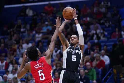 San Antonio Spurs guard Dejounte Murray (5) shoots against New Orleans Pelicans forward Herbert Jones (5) in the first half of an NBA basketball game in New Orleans, Saturday, March 26, 2022. (AP Photo/Gerald Herbert)
