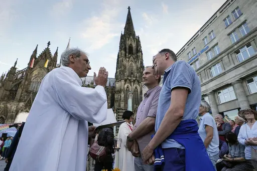 Same-sex couples take part in a public blessing ceremony in front of the Cologne Cathedral in Cologne, Germany, on Sept. 20, 2023. Pope Francis has formally approved allowing priests to bless same-sex couples, with a new document released Monday Dec. 18, 2023 explaining a radical change in Vatican policy by insisting that people seeking God’s love and mercy shouldn’t be subject to “an exhaustive moral analysis” to receive it. (AP Photo/Martin Meissner, File)