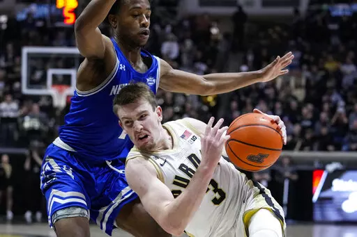 Purdue guard Fletcher Loyer (2) falls as he drives around New Orleans guard Jordan Johnson (1) during the second half of an NCAA college basketball game in West Lafayette, Ind., Wednesday, Dec. 21, 2022. (AP Photo/Michael Conroy)