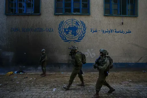 Israeli soldiers take position as they enter the UNRWA headquarter where the military discovered tunnels underneath of the U.N. agency that the military says Hamas militants used to attack its forces during a ground operation in Gaza, Thursday, Feb. 8, 2024. The Israeli military says it has discovered tunnels underneath the main headquarters of the U.N. agency for Palestinian refugees in Gaza City, alleging that Hamas militants used the space as an electrical supply room. The unveiling of the tu