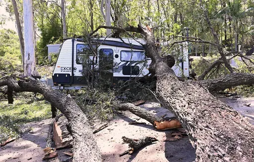 A fallen tree lays across a camping trailer near the Gold Coast, Australia Tuesday, Dec. 26, 2023. At least nine people have died in wild weather in the Australian eastern states of Queensland and Victoria, officials said on Wednesday. (Dave Hunt/AAP Image via AP)