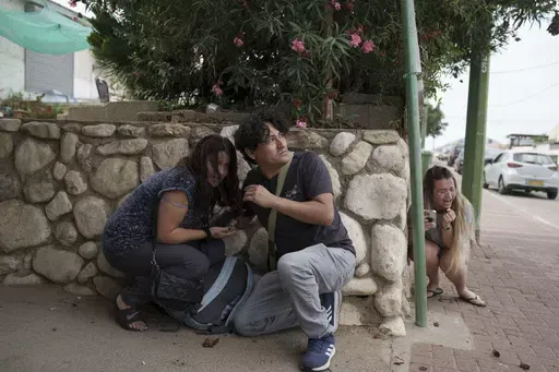 Israelis take cover from the incoming rocket fire from the Gaza Strip in Ashkelon, southern Israel on Oct. 11, 2023. (AP Photo/Leo Correa, File)