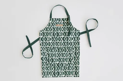 This image provided by Minted shows an apron featuring the fabric print creativity of one of Minted's community of independent artists, Luz Alliat. This adult's apron's pattern is called Outdoors. Aprons can be personalized with a custom foil-pressed leather name tag. (Minted via AP)