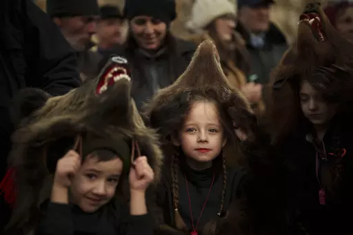 Sofia, 6 years-old, center, a members of a traditional bear pack takes part in a parade before performing in a festival in Moinesti, northern Romania, Wednesday, Dec. 27, 2023. Centuries ago, people in what is now northeastern Romania would don bear fur and dance to fend off evil spirits. Nowadays, the unique custom thrives, with popular festivals drawing large crowds of locals and tourists. (AP Photo/Vadim Ghirda)