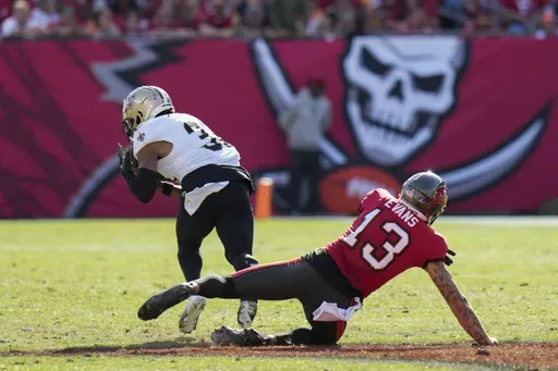 New Orleans Saints safety Jordan Howden intercepts a deflected pass intended for Tampa Bay Buccaneers wide receiver Mike Evans (13) during the second half of an NFL football game Sunday, Jan. 5, 2025, in Tampa, Fla. (AP Photo/Chris O'Meara)