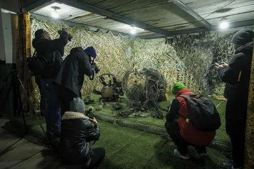 Journalists at a center for forensic analysis in undisclosed location in Ukraine on Nov. 24, 2024, film fragments of what authorities in Kyiv described as a Russian hypersonic missile that struck a factory in Dnipro, Ukraine, on Nov. 21. (AP Photo/Evgeniy Maloletka, File)