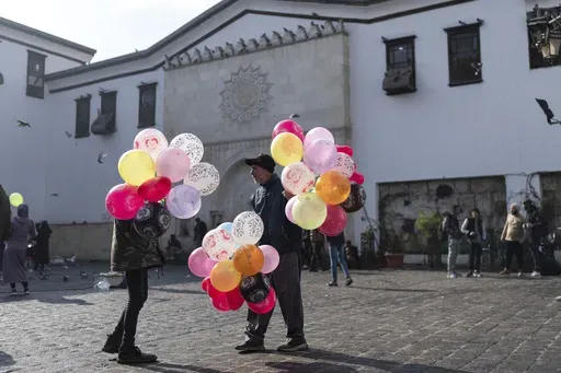 Balloon sellers wait for customers near Al-Hamidiyeh Souq on New Years Eve, in Damascus, Syria, Tuesday, Dec. 31, 2024. (AP Photo/Mosa'ab Elshamy)