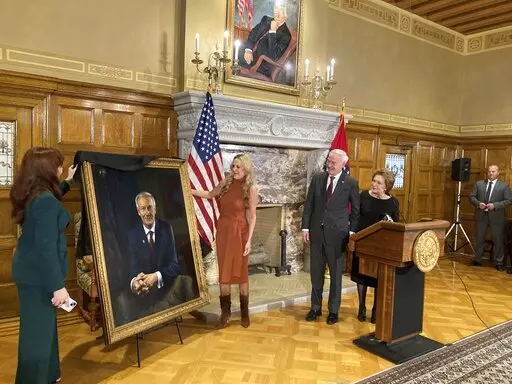 CORRECTS NAME TO SARAH WENGEL, NOT SUSAN WENGEL -Arkansas Gov. Asa Hutchinson and first lady Susan Hutchinson look on as their granddaughter, Jaella Wengel, left, and daughter, Sarah Wengel, center, unveil the governor's official portrait on Tuesday, Jan. 3, 2023, at the state Capitol in Little Rock, Ark. Hutchinson will leave office on Jan. 10 after serving eight years as governor. (AP Photo/Andrew DeMillo)