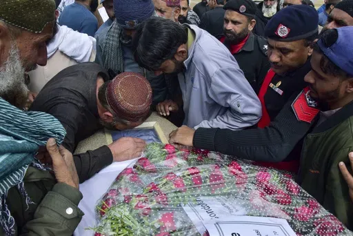 Mourners gather around a casket of a victim of a train attack, for a funeral prayer in Quetta, Pakistan's southwestern Balochistan province, Thursday March 13, 2025. (AP Photo/Arshad Butt)