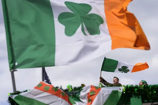 A person waves an Irish flag while watching the St. Patrick's Day parade, Sunday, March 17, 2024, in Boston's South Boston neighborhood. (AP Photo/Steven Senne, File)