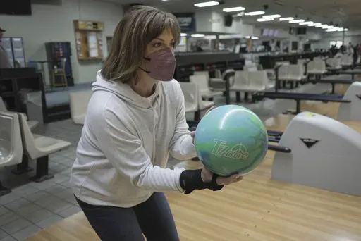 Susan Scarbro bowls while wearing a mask in Little River, S.C. on Jan. 3, 2025. (AP Photo/Laura Bargfeld)