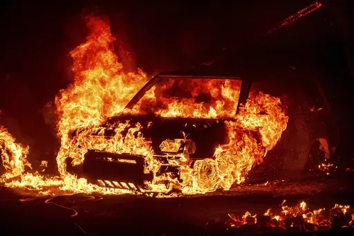 Flames consume a vehicle as the Park Fire jburns in Tehama County, Calif., on Friday, July 26, 2024. (AP Photo/Noah Berger)