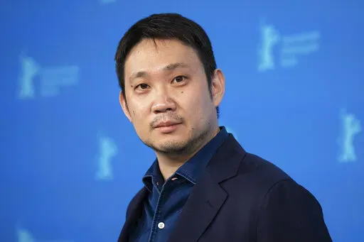 Jury member and filmmaker Ryusuke Hamaguchi poses for photographers at the photo call for the jury at the International Film Festival Berlin in Berlin, Germany on Feb. 10, 2022. Hamaguchi is nominated for an Oscar for best director for "Drive My Car." (Photo by Vianney Le Caer/Invision/AP, File)
