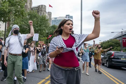 Alia Amanpour Trapp, center, reacts to car horns as she leads the crowd during a pro-Palestine rally and march on Temple University campus in Philadelphia, Aug. 29, 2024. (AP Photo/Chris Szagola)