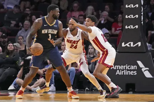 New Orleans Pelicans forward Zion Williamson (1) looks for an opening past Miami Heat forward Haywood Highsmith (24) and guard Dru Smith (12) during the first half of an NBA preseason basketball game, Sunday, Oct. 13, 2024, in Miami. (AP Photo/Wilfredo Lee)