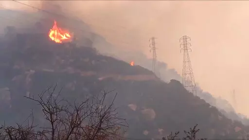 In this Saturday, Dec. 16, 2017, file image taken from video provided by the Santa Barbara County Fire Department, spot fires burn near power lines as heavy smoke fills the air from a wildfire in Santa Barbara, Calif. The nation's largest utility, Pacific Gas & Electric is poised to emerge from five years of criminal probation amid worries that it remains too dangerous to be trusted. Over the five years, the utility became an even more destructive force. More than 100 people have died and thousa