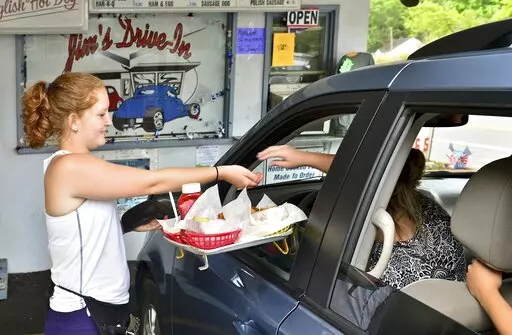  In this Tuesday June 23, 2015 photo, Jim's Drive-In waitress Aly King delivers an order to a waiting customer at the iconic restaurant in Lewisburg, W.Va. A program offering $20,000 in cash and incentives for remote workers to move to West Virginia as part of a population push has chosen 33 people for its second class of newcomers to live in the Greenbrier Valley, which includes Lewisburg. (Bob Wojcieszak/Daily Mail via AP, File)
