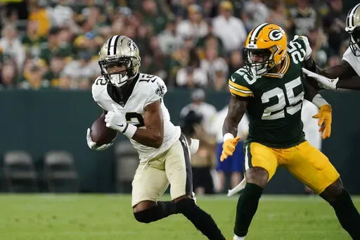 New Orleans Saints wide receiver Chris Olave (12) carries on a reception during the first half of a preseason NFL football game against the Green Bay Packers Friday, Aug. 19, 2022, in Green Bay, Wis. (AP Photo/Morry Gash)