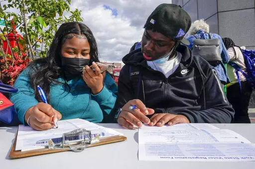 Residents of the Flatbush neighborhood of the Brooklyn borough of New York register to vote at a voter registration event on Sept. 29, 2021. New York's governor has signed a law intended to prevent local officials from enacting rules that might suppress people's voting rights because of their race. The law signed by Gov. Kathy Hochul, Monday, June 20, 2022, will make New York one of the first states to bring back a version of a process known as "preclearance." (AP Photo/Mary Altaffer, File)