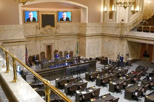 House Republican Leader J.T. Wilcox, R-Yelm, is displayed on video screens as he speaks remotely following opening remarks from House Speaker Laurie Jinkins, D-Tacoma, during the opening session of the Washington state House, Jan. 10, 2022, at the Capitol in Olympia, Wash. As lawmakers in some Democratic-led states meet remotely because of renewed COVID-19 concerns, their counterparts in many Republican-led legislatures are beginning their 2022 sessions with an aggressive push to outlaw vaccine 