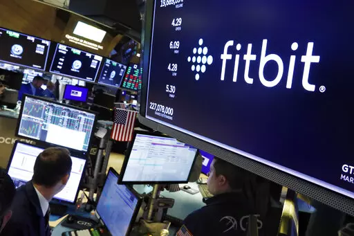 In this Oct. 28, 2019 file photo, the logo for fItbit appears above a trading post on the floor of the New York Stock Exchange.  Google-owned Fitbit has recalled 1 million of its Ionic smartwatches, Wednesday, March 2, 2022 after dozens of users reported burn injuries because the battery overheated. The fitness gadget maker says consumers who bought the $299 watches with the model number FB503 should immediately stop using the product and contact Fitbit for packaging to return them.  (AP Photo/R