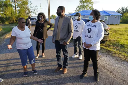 EPA Administrator Michael Regan, center, talks with Brenda Bryant, left, and other members of the group Rise St. James, as he tours a neighborhood next to the Nu Star Energy oil storage tanks, in St. James Parish, La., Nov. 16, 2021. The Biden administration is granting Louisiana's request to administer its own permit program for wells that store carbon dioxide. It will be just the third state to take over that job from the EPA. The EPA said the Louisiana agreement includes safeguards to protect