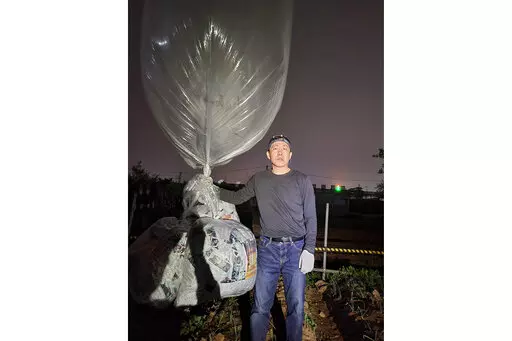 Park Sang-hak, a North Korean defector-turned-activist, prepares to release a balloon bearing leaflets at the border town of Gimpo, South Korea, on April 25, 2022. The South Korean activist said Thursday, April 28, he launched a million propaganda leaflets by balloon into North Korea this week, in his first such campaign while standing trial for past leafleting under a contentious new law that criminalizes such actions.(Courtesy of Fighters For A Free North Korea via AP)