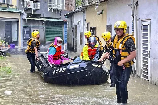 In this photo released by the Taiwan Ministry of National Defense, rescue workers evacuate residents trapped by flood waters in the aftermath of Typhoon Gaemi in Chiayi county in southwestern Taiwan, Friday, July 26, 2024. (Taiwan Ministry of National Defense via AP)