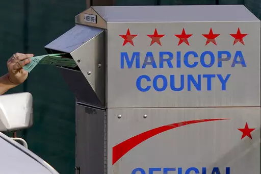 A voter casts their ballot at a secure ballot drop box at the Maricopa County Tabulation and Election Center in Phoenix, Tuesday, Nov. 1, 2022.  On Friday, Nov. 11, The Associated Press reported on stories circulating online incorrectly claiming when ballots were rejected by tabulators at some voting locations across Maricopa County on Election Day, an alternate solution for voters to drop ballots in a secure drop box onsite resulted in the ballots getting shredded, thrown in the trash, or marke