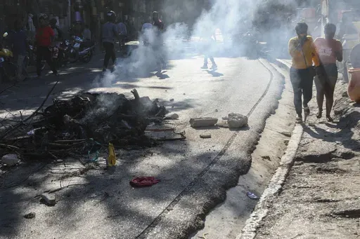 The bodies of suspected gang members who were set on fire by residents, sit in a pile in the middle of a road in the Pétion-Ville neighborhood of Port-au-Prince, Haiti, Tuesday, Nov. 19, 2024. (AP Photo/Odelyn Joseph)
