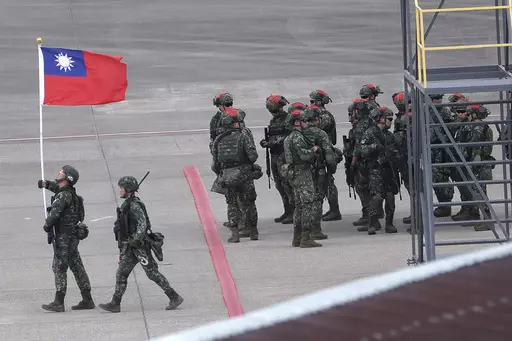 A soldier holds up Taiwan’s national flag during the annual Han Kuang military exercises in Taoyuan, Northern Taiwan, on July 26, 2023. Taiwan’s government is racing to counter China’s military, but many on the island say they don’t share the sense of threat. (AP Photo/Chiang Ying-ying, File)