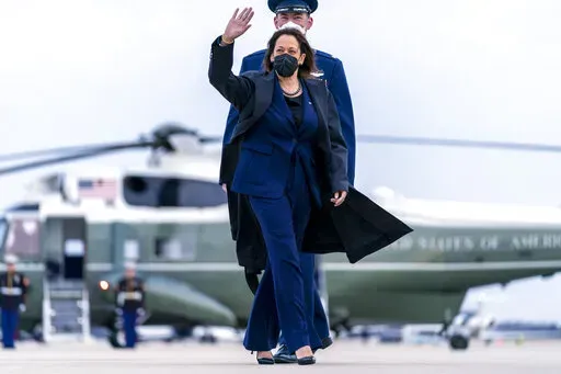 Vice President Kamala Harris, escorted by Maj Guy Evertson, Alt. Director Flight Line Protocol, C-32A Pilot, walks across the tarmac to board her plane at Andrews Air Force Base, Md., Thursday, Feb. 17, 2022, to travel to Munich for the Munich Security Conference. (AP Photo/Andrew Harnik, Pool)