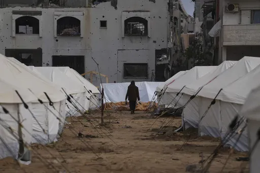 A man walks between tents for displaced Palestinians next to destroyed buildings following the Israeli air and ground offensive in Jabaliya, Gaza Strip, Thursday, Feb. 6, 2025. (AP Photo/Abdel Kareem Hana, file)