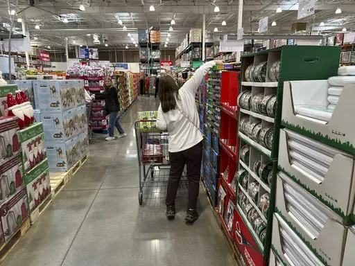Shoppers reach for items on display in a Costco warehouse Nov. 19, 2024, in Lone Tree, Colo. (AP Photo/David Zalubowski, File)