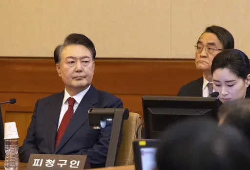 South Korea's impeached President Yoon Suk Yeol, left, attends a hearing of his impeachment trial at the Constitutional Court in Seoul, South Korea, Thursday, Feb. 13, 2025. (Joen Heon-Kyun/Pool Photo via AP)