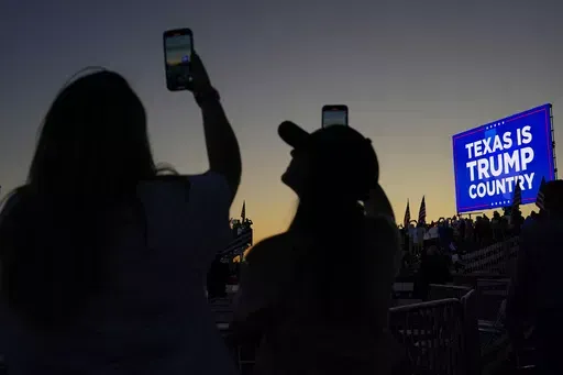 People hold their cellphones as they wait for the plane carrying former President Donald Trump to take off after a campaign rally at Waco Regional Airport Saturday, March 25, 2023, in Waco, Texas. Brad Parscale, the digital campaign operative who helped engineer Trump’s 2016 presidential victory, vows that his new, AI-powered platform will dramatically overhaul how campaigns are run. (AP Photo/Nathan Howard, File)