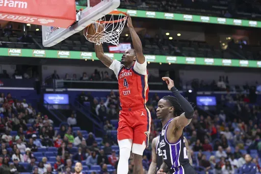New Orleans Pelicans guard Javonte Green (4) throws down a fast break dunk against Sacramento Kings guard Keon Ellis (23) during the first half of an NBA basketball game in New Orleans, Thursday, Feb. 13, 2025. (AP Photo/Peter Forest)