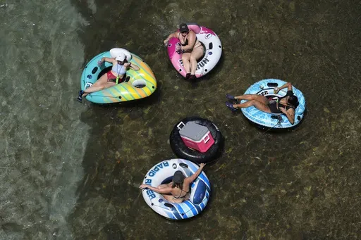 Tubers float the cool Comal River as temperatures in South Texas hit triple-digit numbers, Wednesday, Aug. 21, 2024, in New Braunfels, Texas. (AP Photo/Eric Gay)