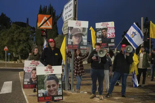 Israeli demonstrators outside the prime minister's office in Jerusalem hold photos of Liri Albag and other hostages during a protest calling for their release from being held in the Gaza Strip by the Hamas militant group, Sunday, Jan. 5, 2025. (AP Photo/Ohad Zwigenberg)
