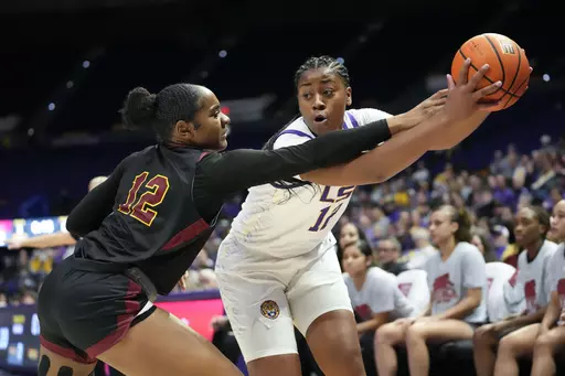 LSU forward Mikaylah Williams (12) moves the ball against Loyola New Orleans Morgan Hervey (12) in the first half an NCAA college basketball exhibition game in Baton Rouge, La., Wednesday, Nov. 1, 2023. (AP Photo/Gerald Herbert)