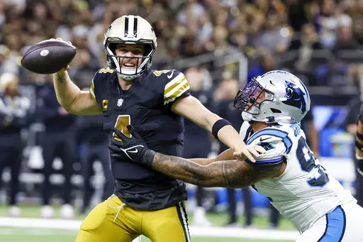 New Orleans Saints quarterback Derek Carr looks to pass under pressure by Carolina Panthers linebacker Yetur Gross-Matos during the first half of an NFL football game in New Orleans, Sunday, Dec. 10, 2023. (AP Photo/Butch Dill)