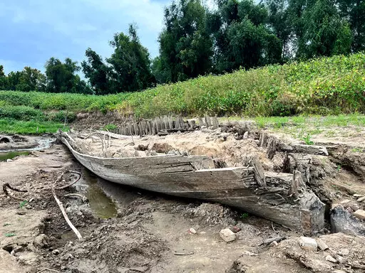 The remains of a ship lay on the banks of the Mississippi River in Baton Rouge, La., on Monday, Oct. 17, 2022, after recently being revealed due to the low water level. The ship, which archaeologists believe to be a ferry that sunk in the late 1800s to early 1900s, was spotted by a Baton Rouge resident walking along the shore earlier this month. (AP Photo/Sara Cline)
