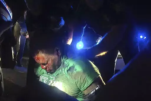This image from video from Louisiana State Police Trooper Dakota DeMoss' body-worn camera shows troopers holding up Ronald Greene before paramedics arrived on May 10, 2019, outside of Monroe, La. No longer waiting for a federal investigation, state prosecutor Union Parish District Attorney John Belton says he intends to pursue his own case against the Louisiana troopers involved in the deadly 2019 arrest of Greene. (Louisiana State Police via AP, File)