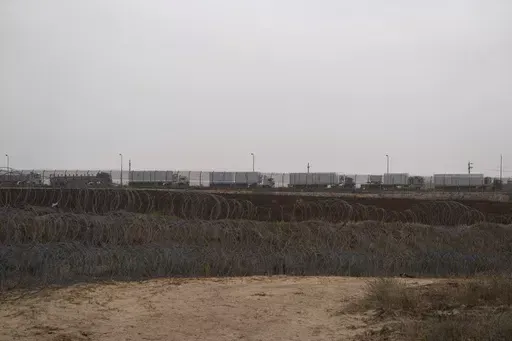 Trucks, carrying humanitarian supplies for the Gaza Strip, wait in line on the Egyptian side, at the Kerem Shalom Crossing border as seen from southern Israel, on April 25, 2024. An influx of aid appears to have eased a hunger crisis in northern Gaza for now, but the entire territory remains at “high risk” of famine after Israel's offensive in Rafah caused massive displacement and the disruption of aid operations in the south, a draft report said Monday. (AP Photo/Leo Correa, File)
