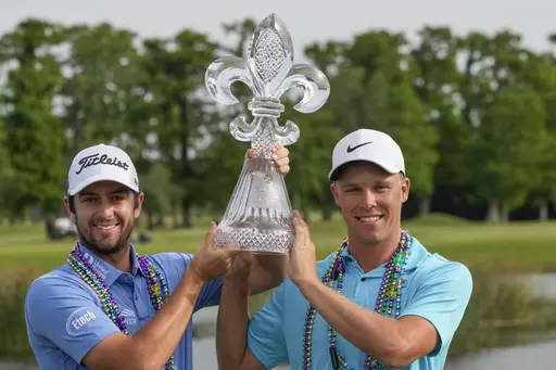 Davis Riley, left, and teammate Nick Hardy hoist their trophy after winning the PGA Zurich Classic golf tournament at TPC Louisiana in Avondale, La., Sunday, April 23, 2023. (AP Photo/Gerald Herbert)