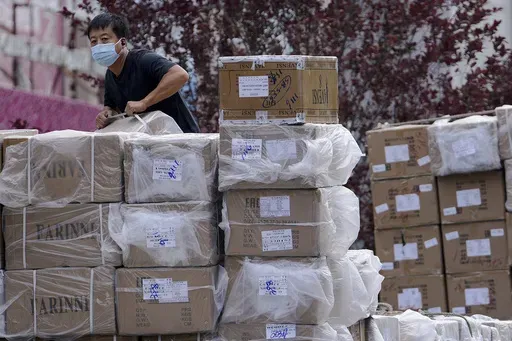 A worker loads boxes of goods from a truck outside a wholesale clothing mall in Beijing on June 14, 2022. (AP Photo/Andy Wong, File)