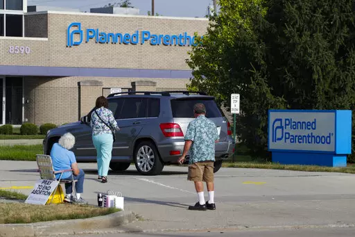Abortion protesters attempt to hand out literature as they stand in the driveway of a Planned Parenthood clinic in Indianapolis, Aug. 16, 2019. Hospitals and abortion clinics in Indiana are preparing for the state's abortion ban to go into effect on Sept. 15, 2022. Starting Sept. 15, abortions will be permitted only in cases of rape and incest, before 10-weeks post-fertilization; to protect the life and physical health of the patient; and if a fetus is diagnosed with a lethal anomaly. The law al